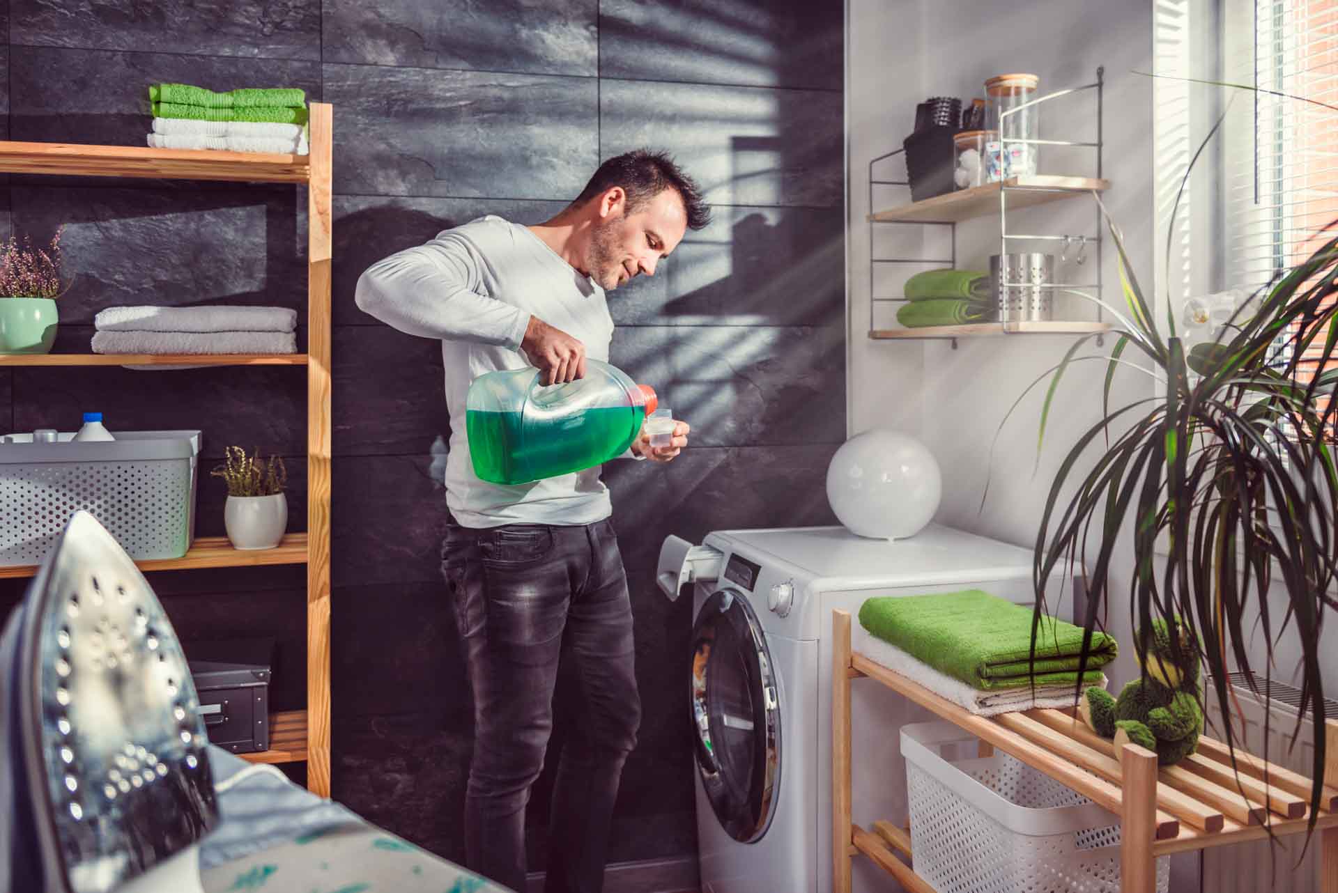 Man filling detergent into washing machine