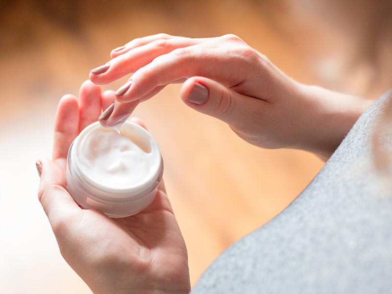 woman holding skin care cream